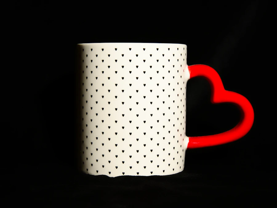 A white mug with a printed heart pattern and a red heart-shaped handle